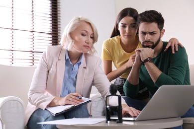 Female notary working with young couple in office