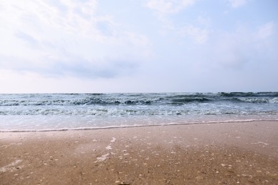 Photo of Sandy beach washed by sea on sunny day