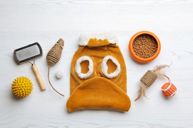 Photo of Flat lay composition with clothes, food and accessories for cat on white wooden table