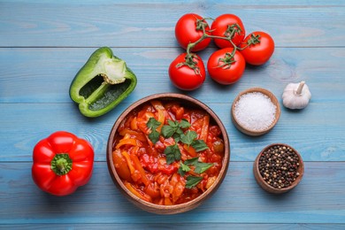 Photo of Delicious lecho and ingredients on light blue wooden table, flat lay