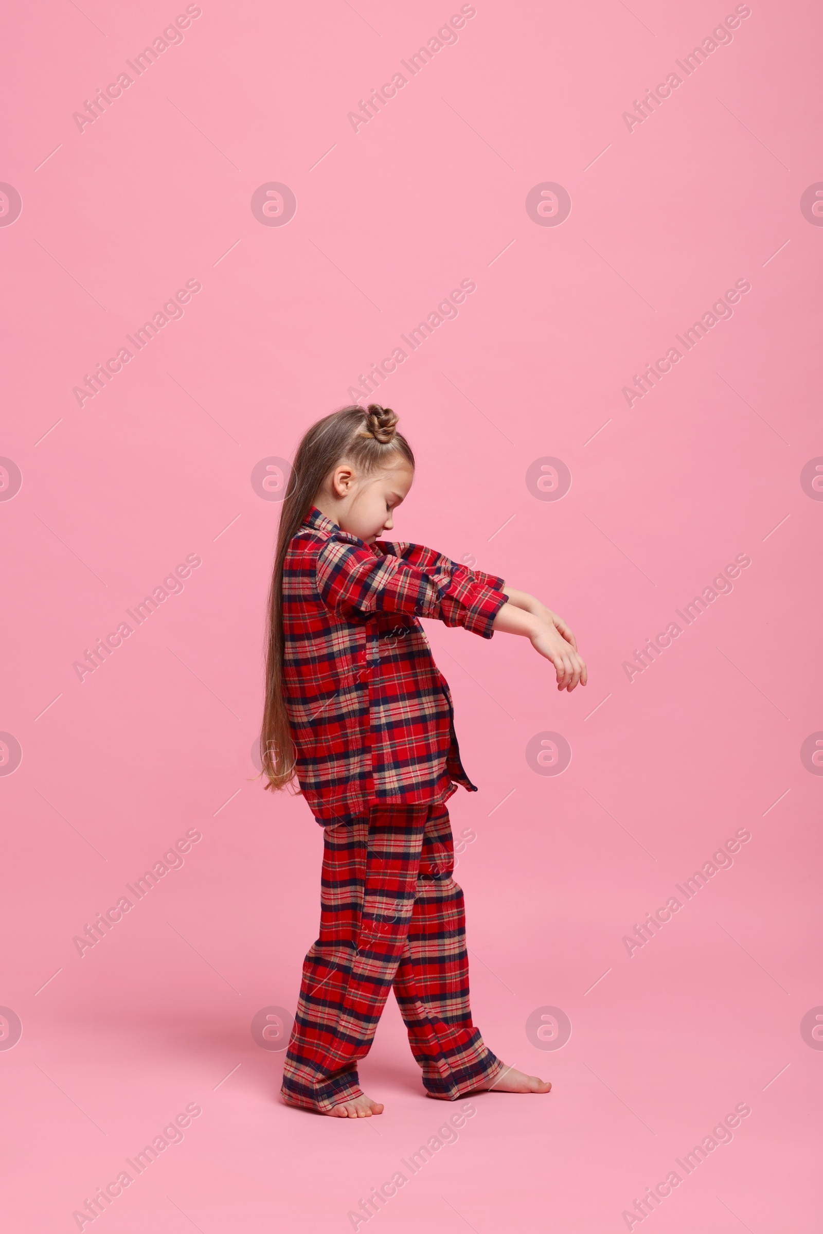 Photo of Girl in pajamas sleepwalking on pink background