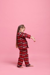 Photo of Girl in pajamas sleepwalking on pink background