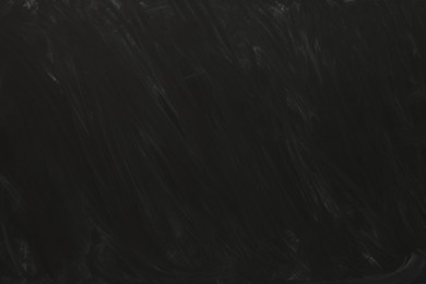 Photo of Dirty black chalkboard as background. School equipment