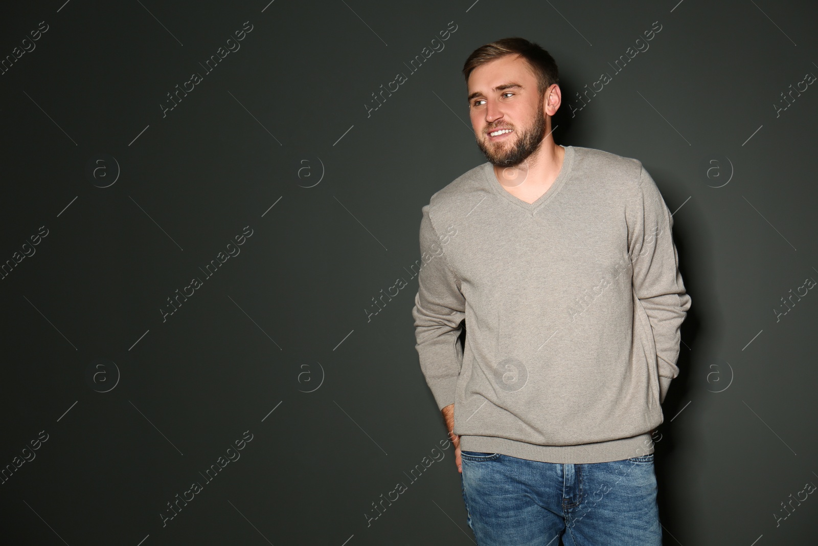 Image of Handsome man wearing warm sweater on dark background. Space for text