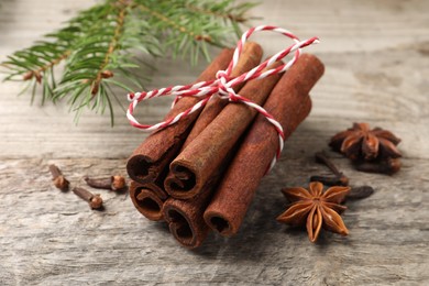 Photo of Different spices. Aromatic cinnamon sticks, anise stars and clove seeds on wooden table, closeup