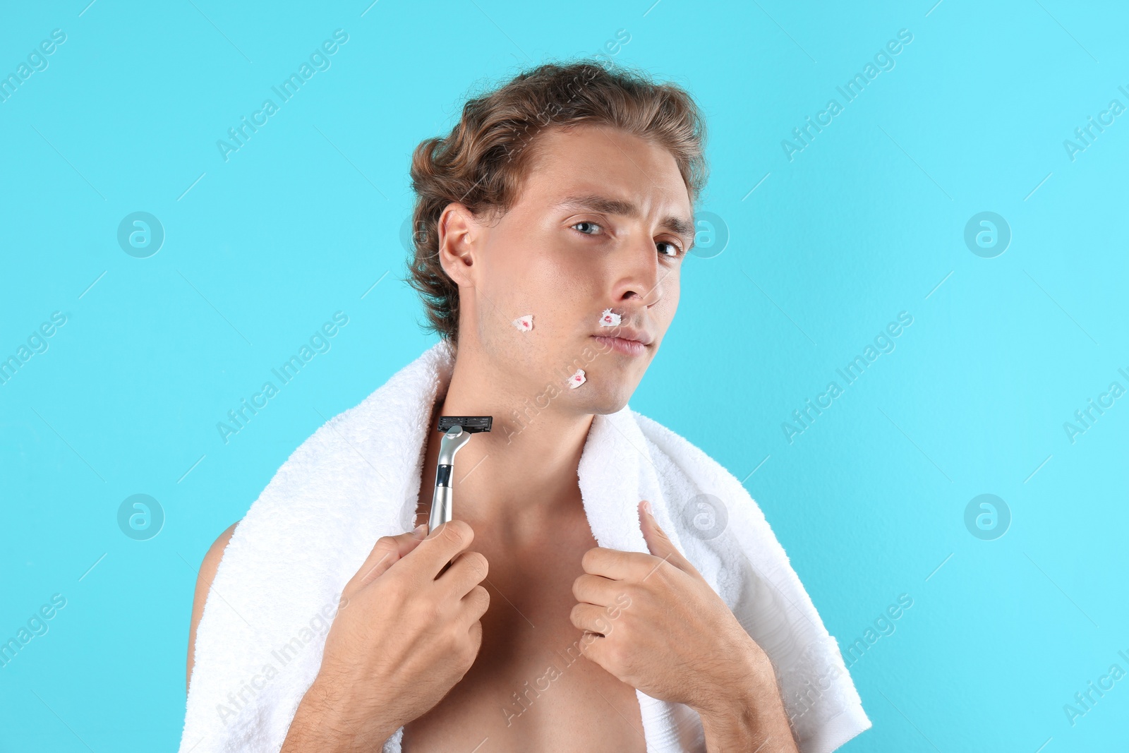 Photo of Young man with face hurt while shaving on color background