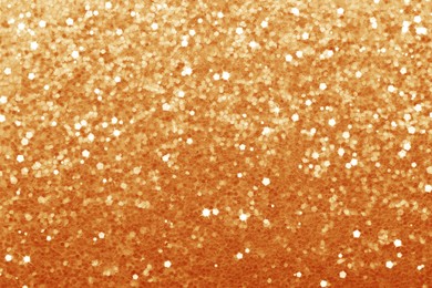 Image of Beautiful shiny orange glitter as background, closeup