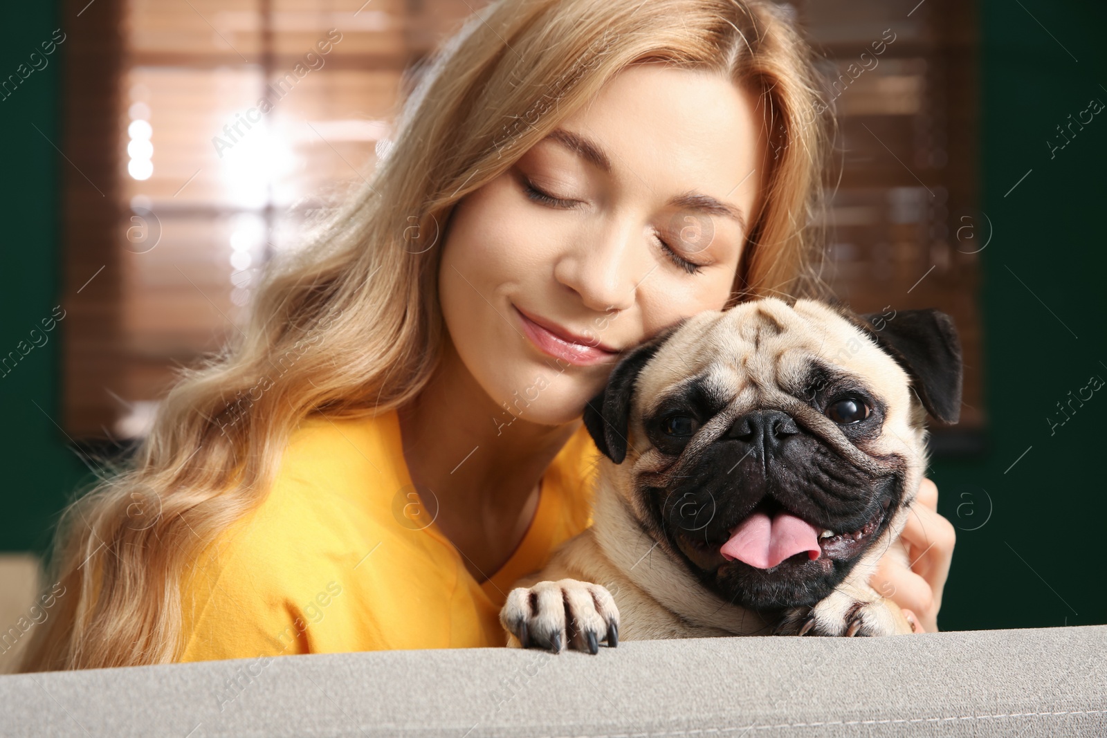 Photo of Woman with cute pug dog at home. Animal adoption