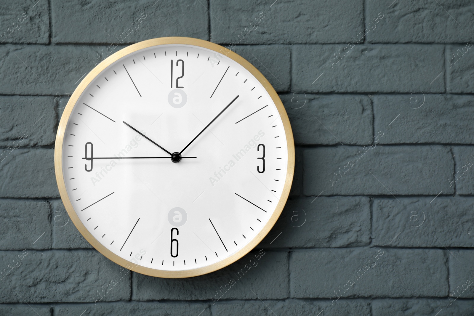 Photo of Modern clock on brick wall. Time concept