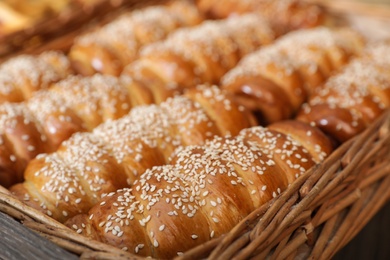 Wicker tray with tasty fresh buns, closeup. Bakery products