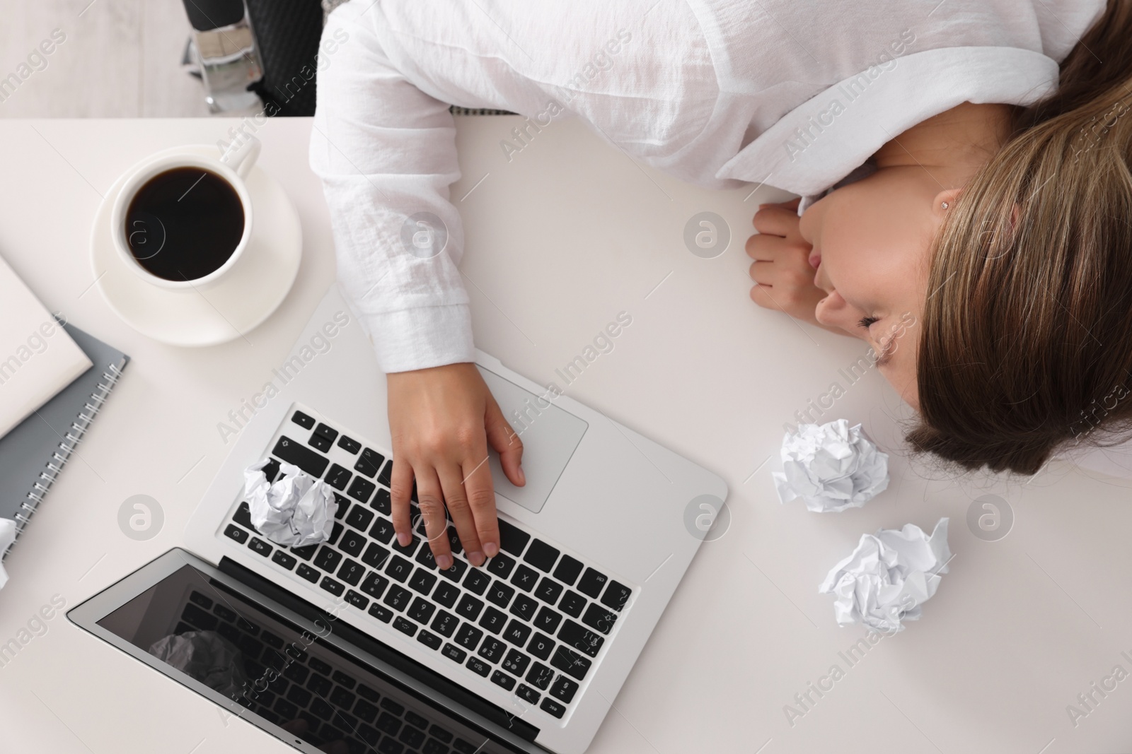 Photo of Young woman sleeping at workplace, top view