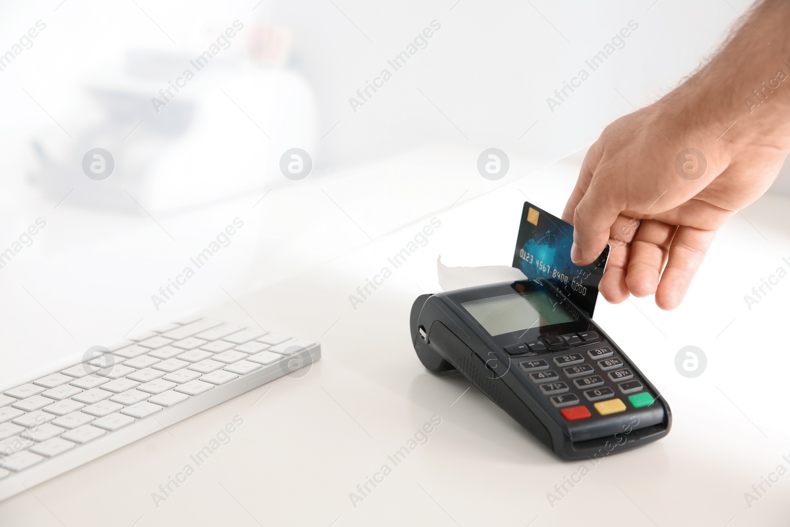 Photo of Man using bank terminal for credit card payment at cash department window, closeup