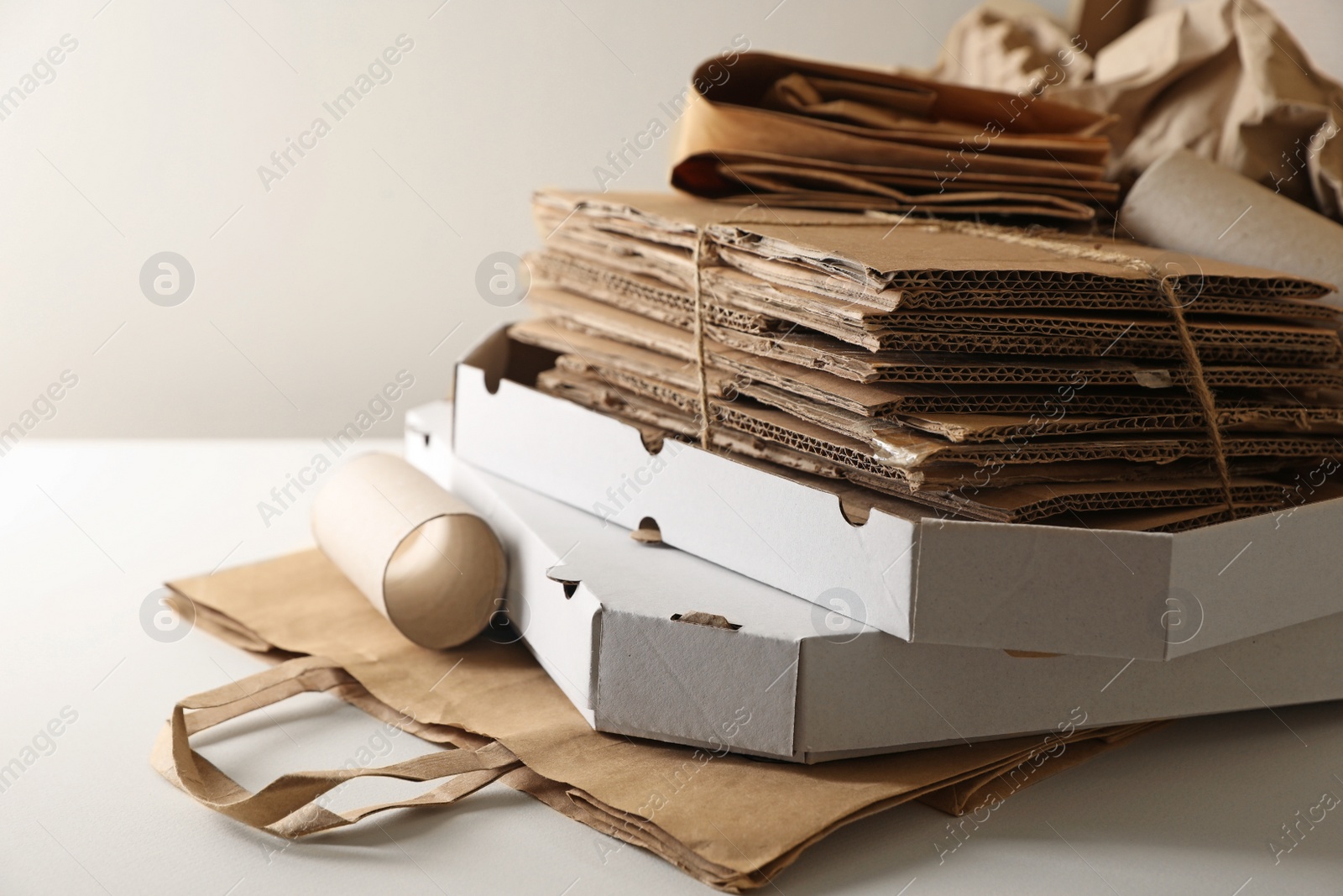 Photo of Stack of different waste paper on beige background, closeup