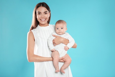 Portrait of happy mother with her baby on color background. Space for text