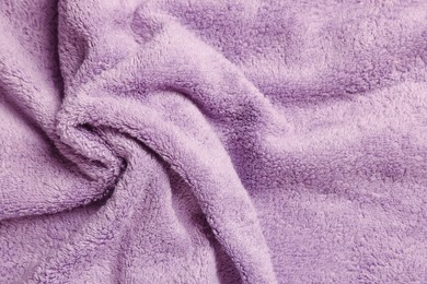 Photo of Soft crumpled pale purple towel as background, top view