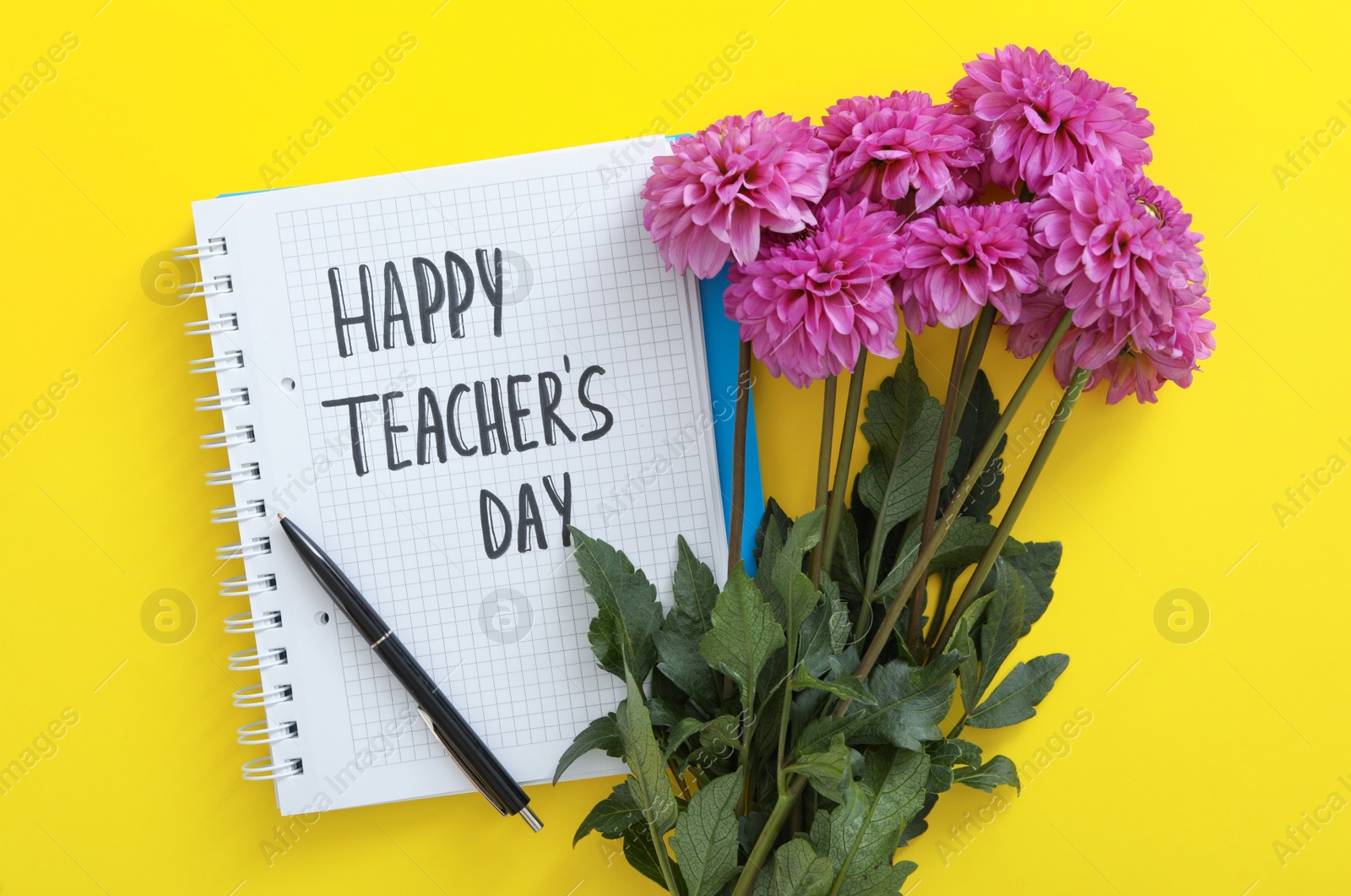 Photo of Beautiful flowers and notebook with words HAPPY TEACHER'S DAY on yellow background, flat lay