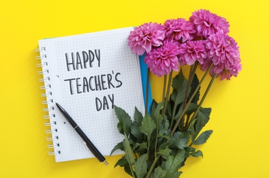 Beautiful flowers and notebook with words HAPPY TEACHER'S DAY on yellow background, flat lay