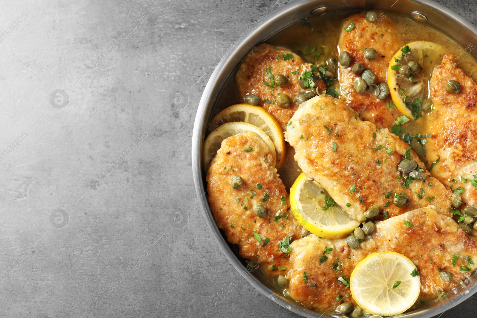 Photo of Delicious chicken piccata on grey table, top view. Space for text