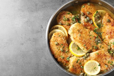 Delicious chicken piccata on grey table, top view. Space for text