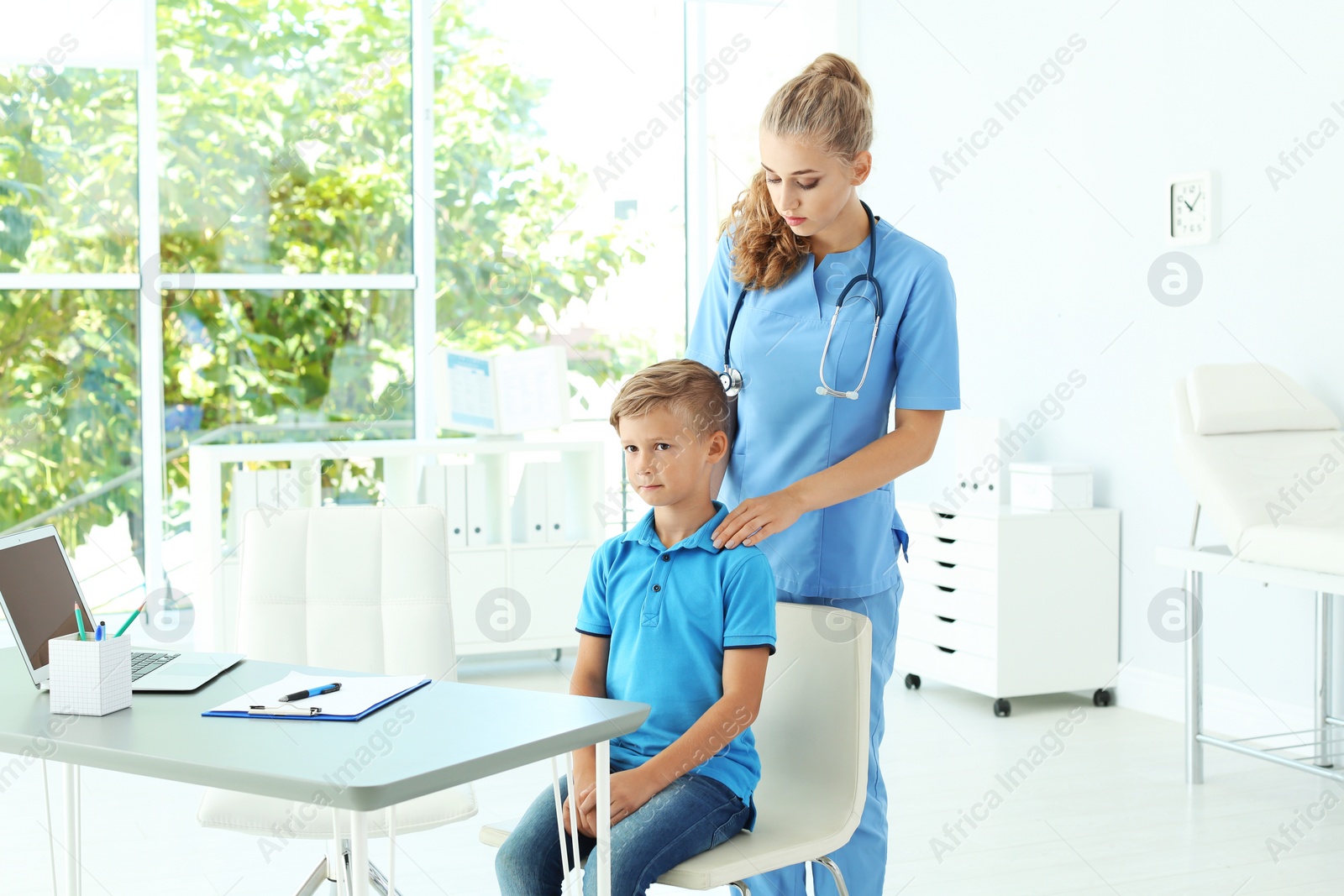 Photo of Female medical assistant examining child in clinic