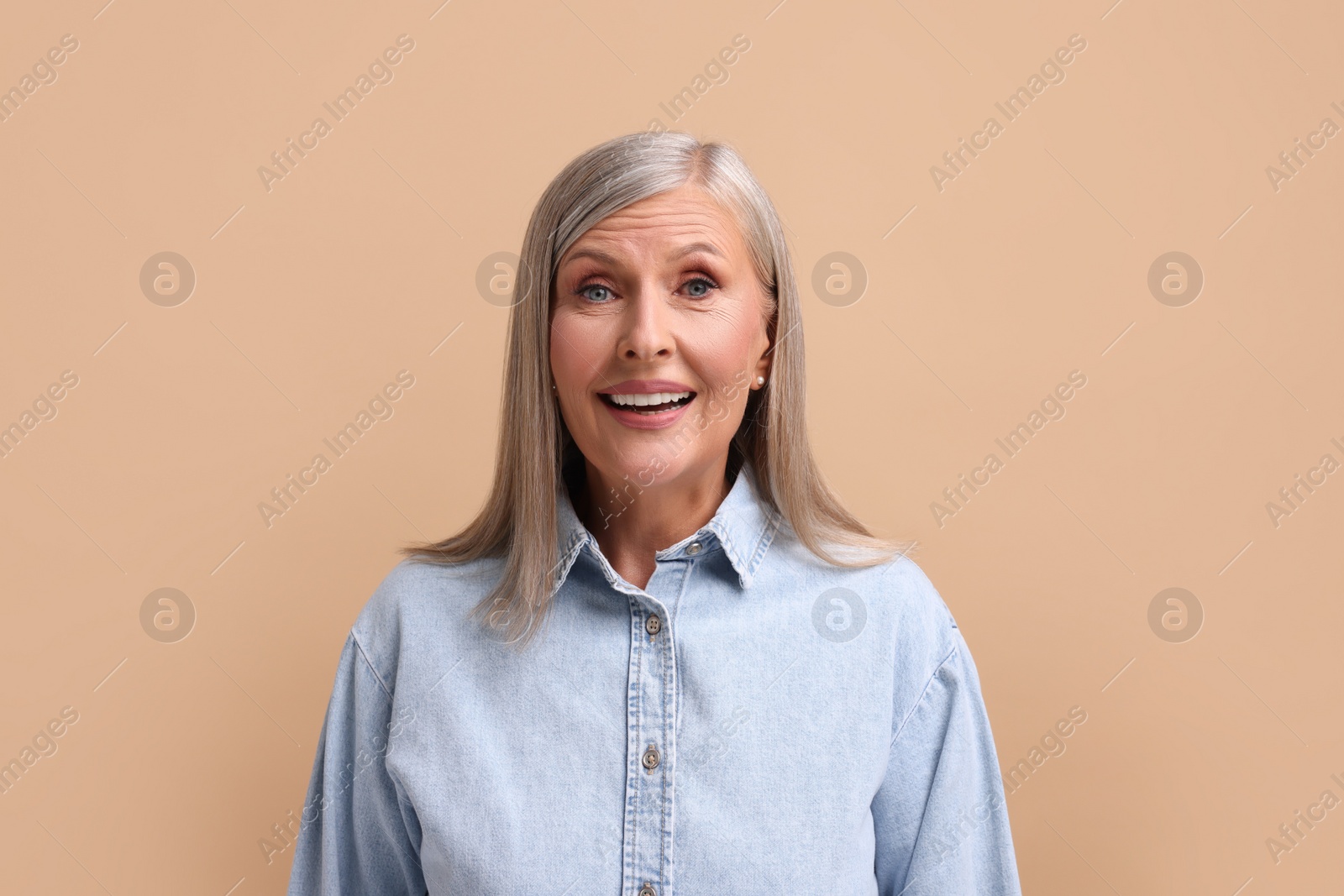 Photo of Portrait of emotional middle aged woman on beige background