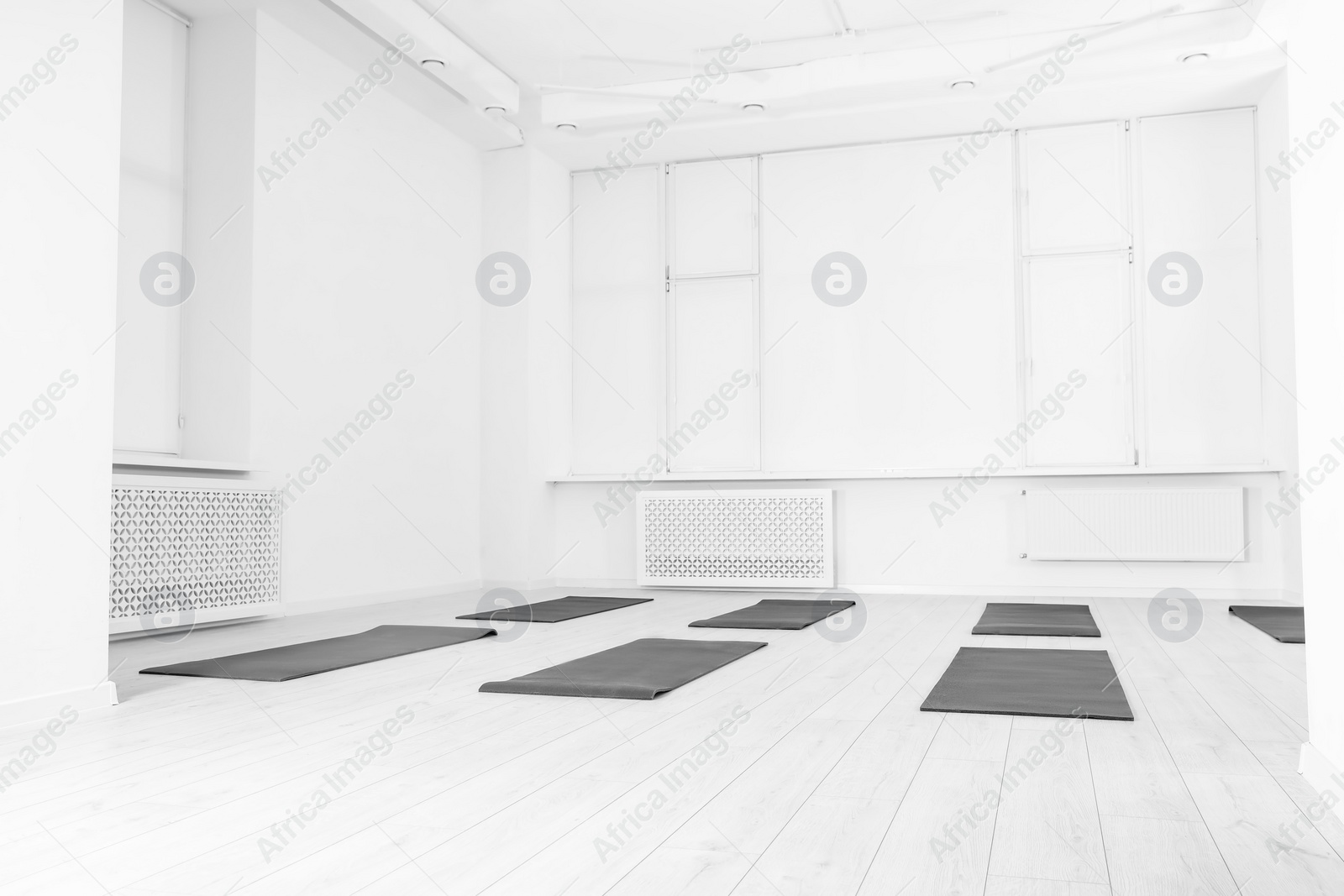 Photo of Spacious yoga studio with exercise mats, low angle view