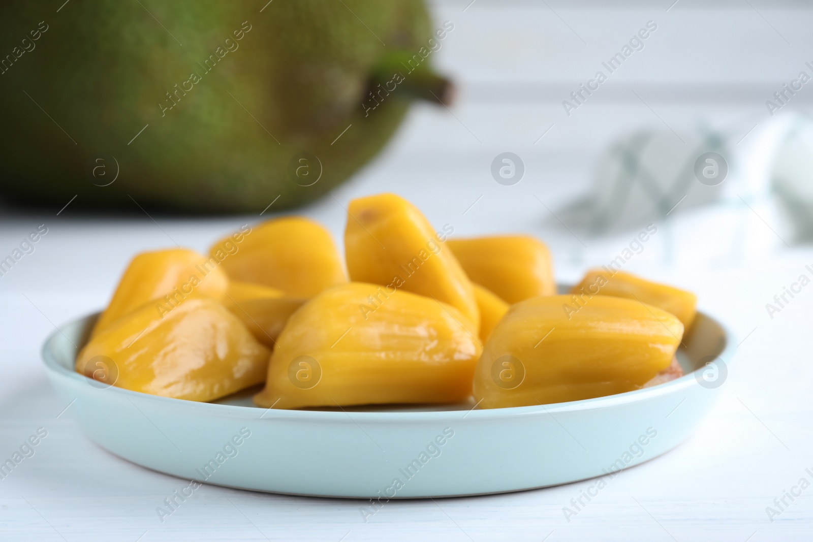 Photo of Delicious exotic jackfruit bulbs on white table, closeup
