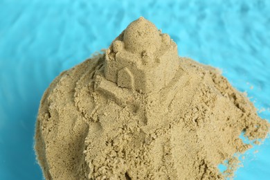 Photo of Pile of sand with sultan's palace on rippled water, closeup. Beautiful castle
