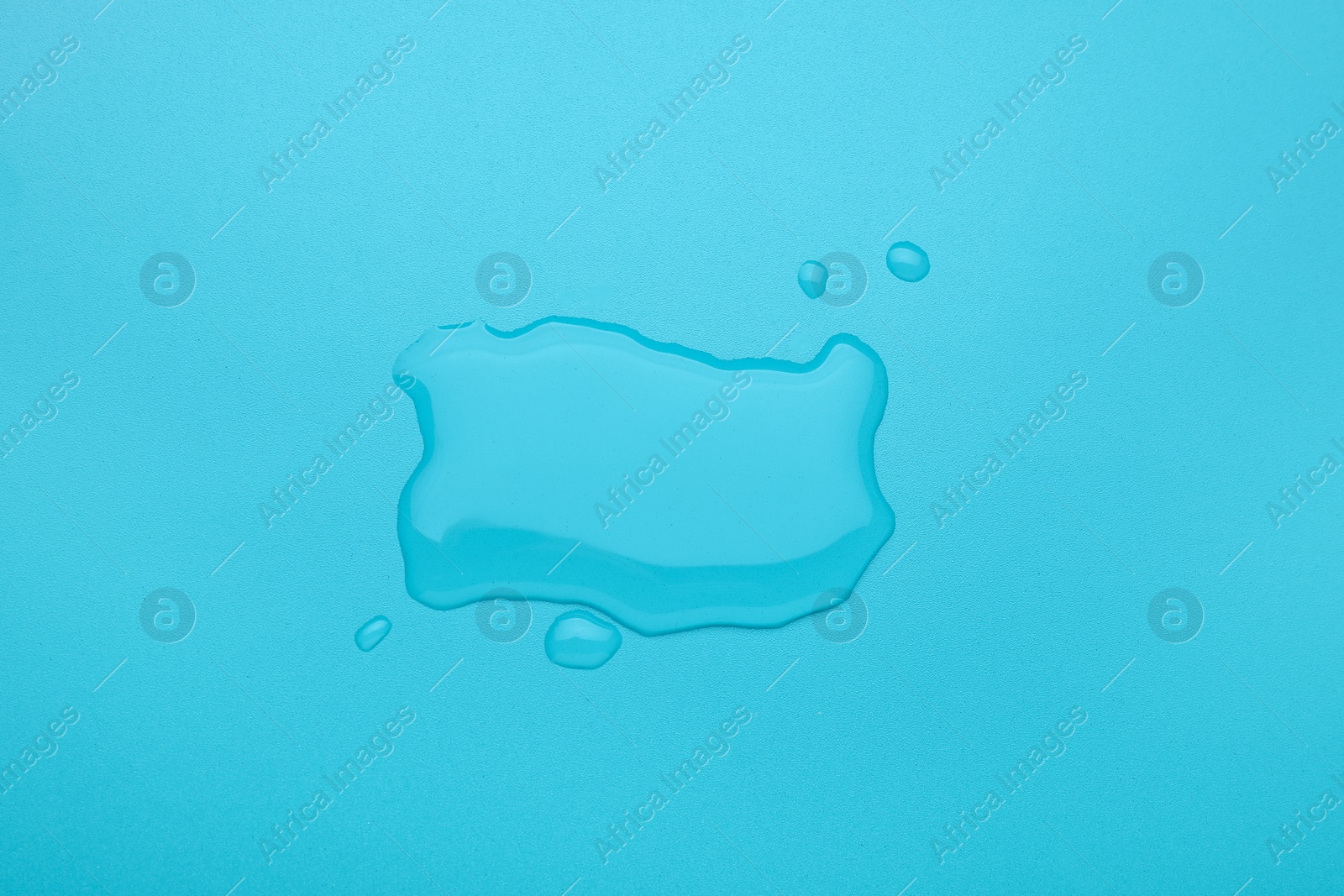 Photo of Puddle of water on light blue background, top view