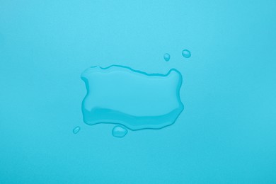 Photo of Puddle of water on light blue background, top view