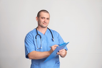 Photo of Portrait of medical assistant with stethoscope and clipboard on color background. Space for text