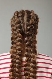 Photo of Woman with braided hair on grey background, back view