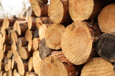 Photo of Stacked firewood outdoors, closeup. Heating in winter