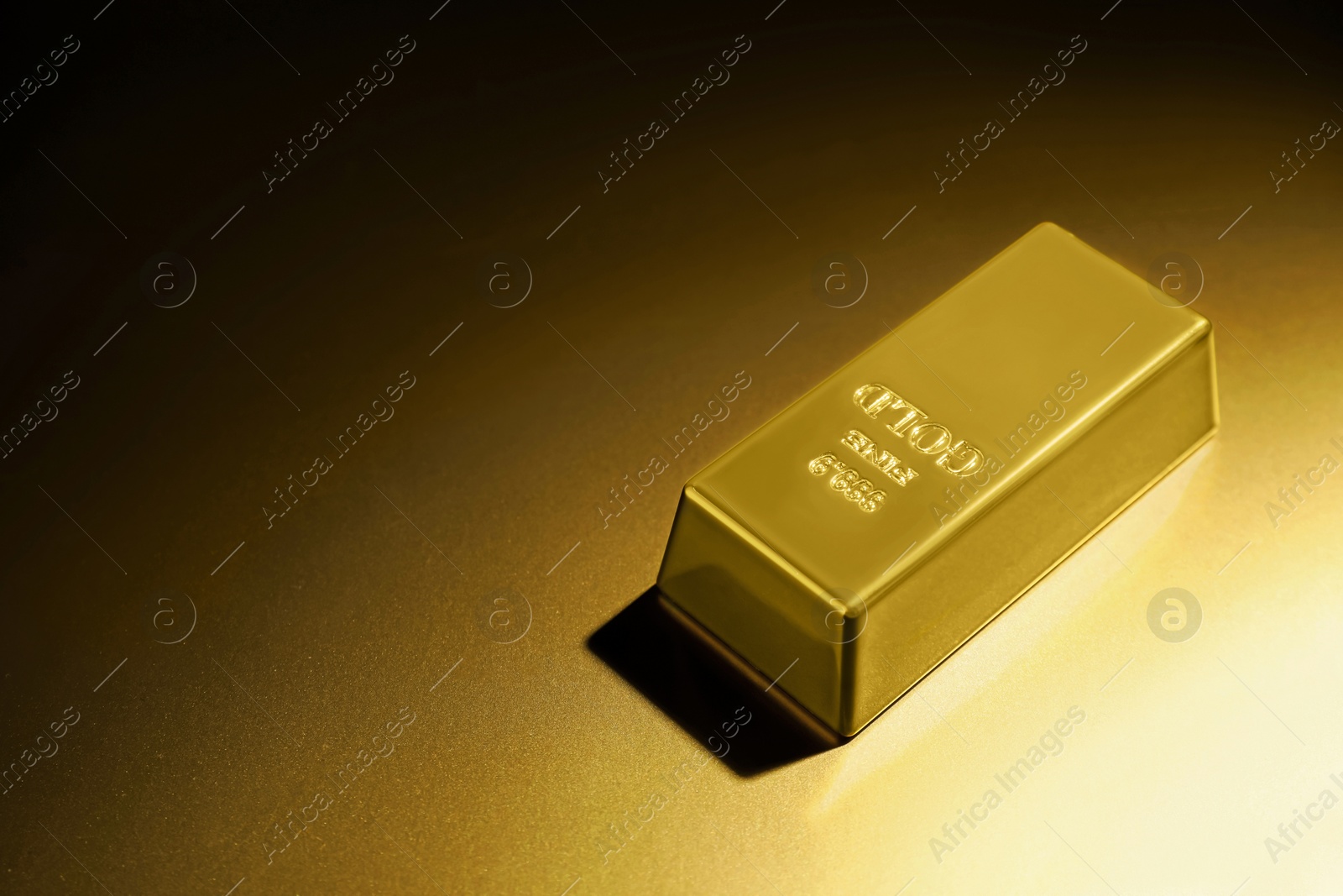 Photo of Shiny gold bar on color background, space for text