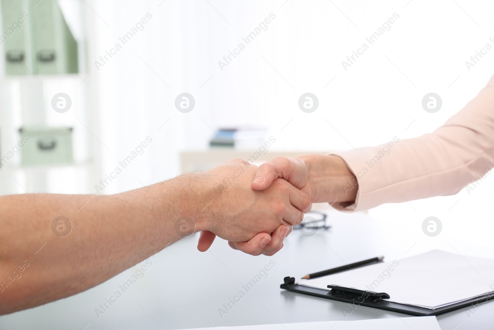 Photo of Lawyer shaking hands with client in office, closeup