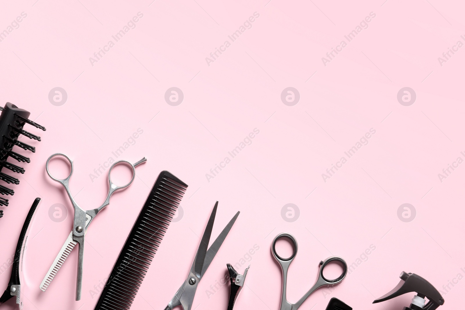 Photo of Scissors and other hairdresser's accessories on pink background, flat lay. Space for text