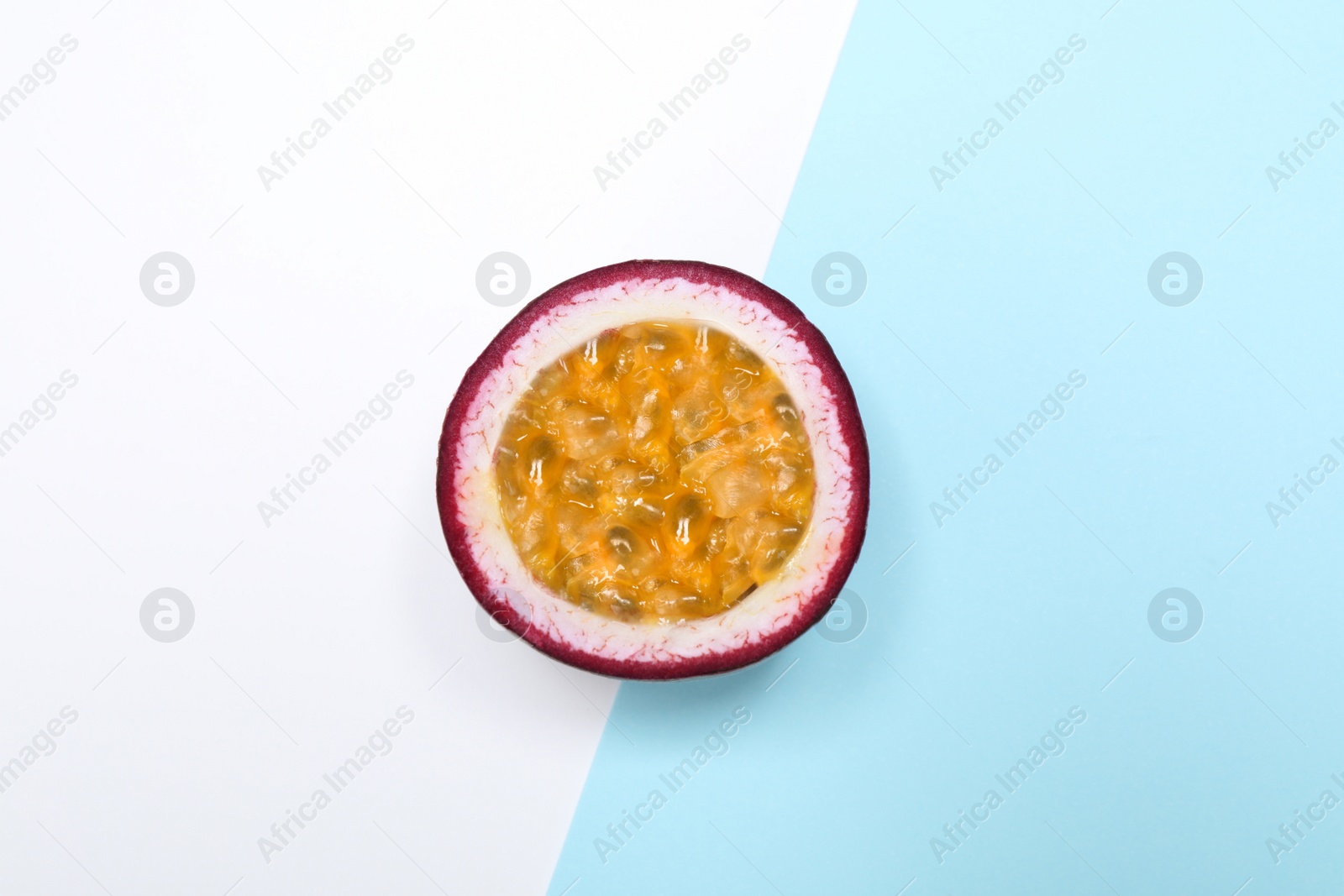 Photo of Half of tasty fresh passion fruit (maracuya) on color background, top view