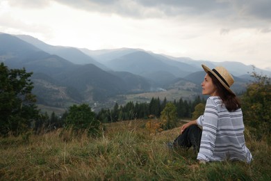 Photo of Woman enjoying beautiful mountains landscape. Space for text