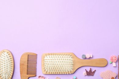 Photo of Flat lay composition with wooden hair brushes on violet background, space for text