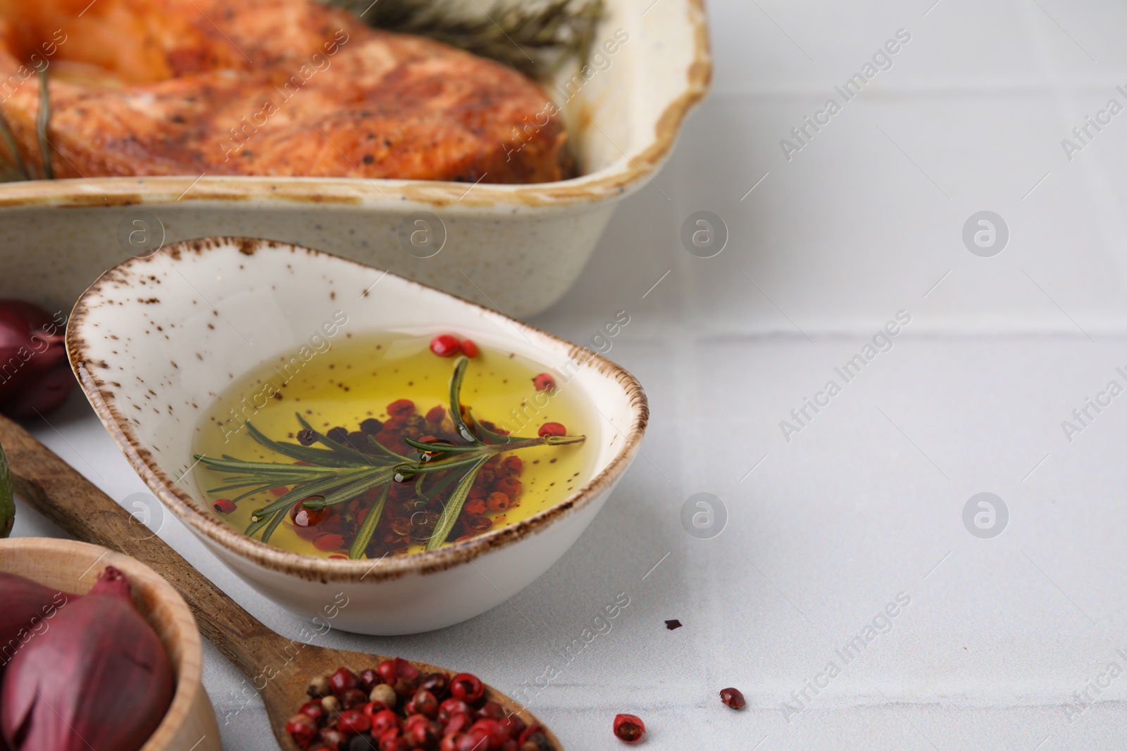 Photo of Fresh marinade and cooked fish on white tiled table, closeup. Space for text