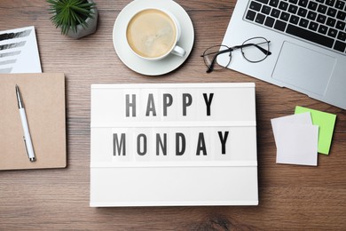 Light box with message Happy Monday, office stationery and cup of coffee on wooden desk, flat lay