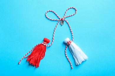 Photo of Traditional martisor on light blue background, top view. Beginning of spring celebration