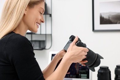 Photo of Professional photographer with modern digital camera indoors