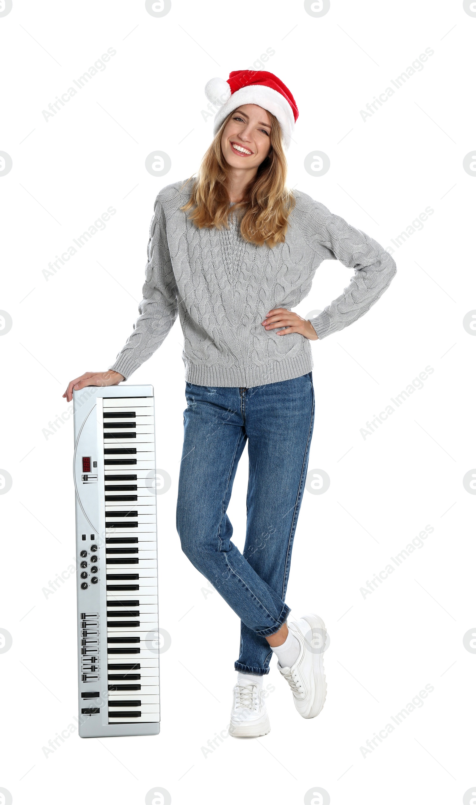 Photo of Young woman in Santa hat with synthesizer on white background. Christmas music