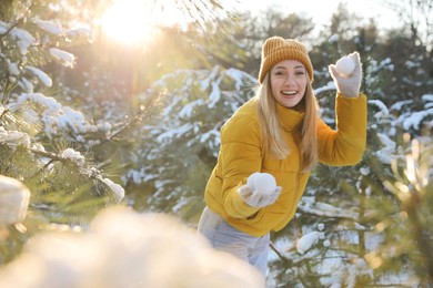 Photo of Woman holding snowballs outdoors on winter day