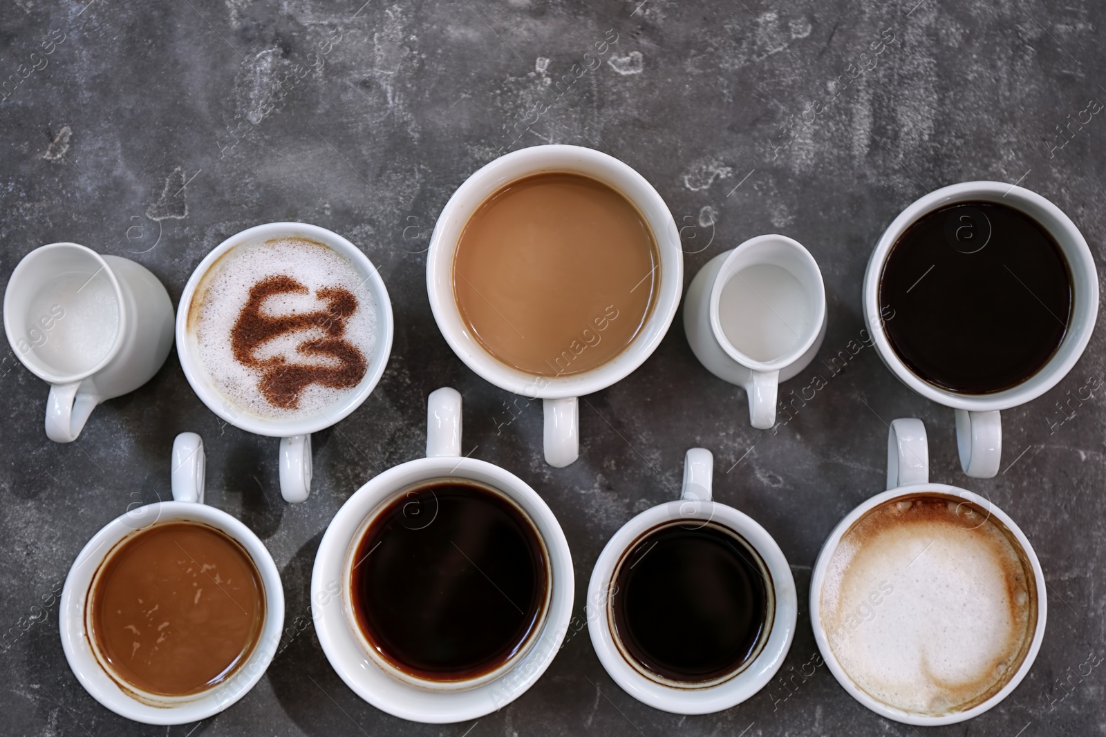 Photo of Cups of fresh aromatic coffee on grey background, top view