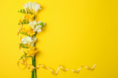 Photo of Beautiful freesia flowers on color background