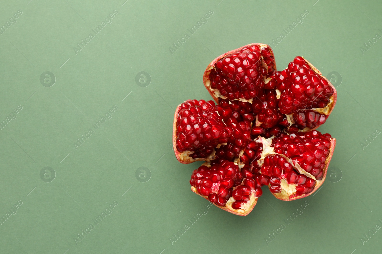 Photo of Fresh ripe pomegranate on pale green background, top view. Space for text