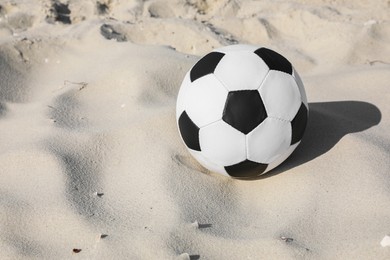 Photo of Soccer ball on sand, space for text. Football equipment