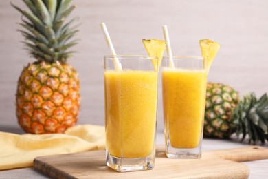 Tasty pineapple smoothie and fresh fruits on table